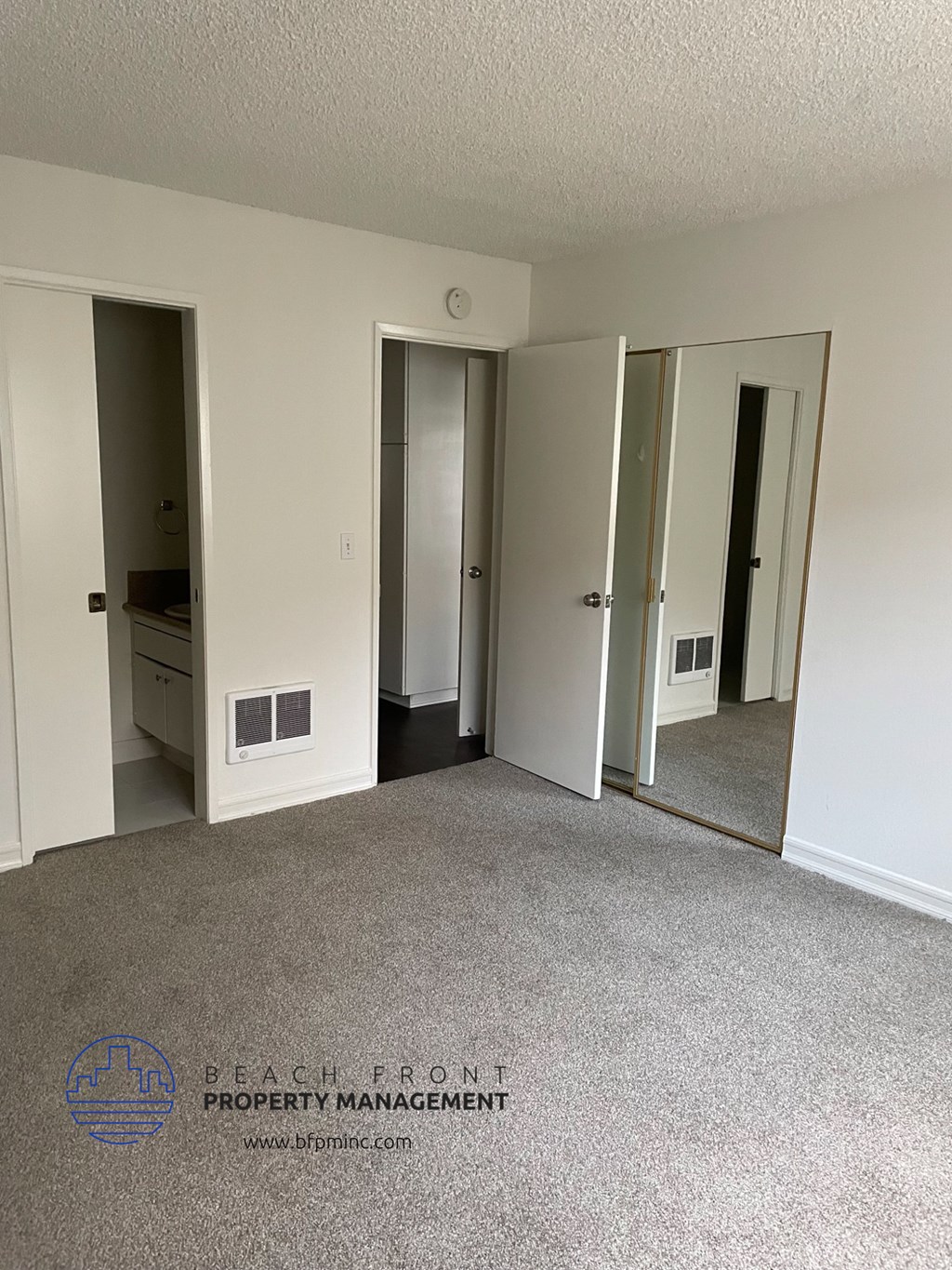 a bedroom with a carpeted floor and a row of mirrors